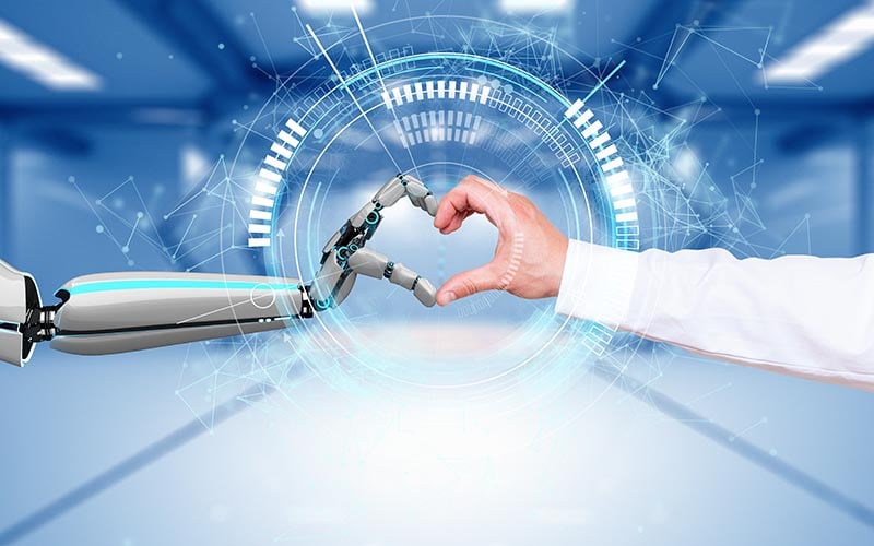 mensschliche Hand und eine Roboterhand formen ein Herz